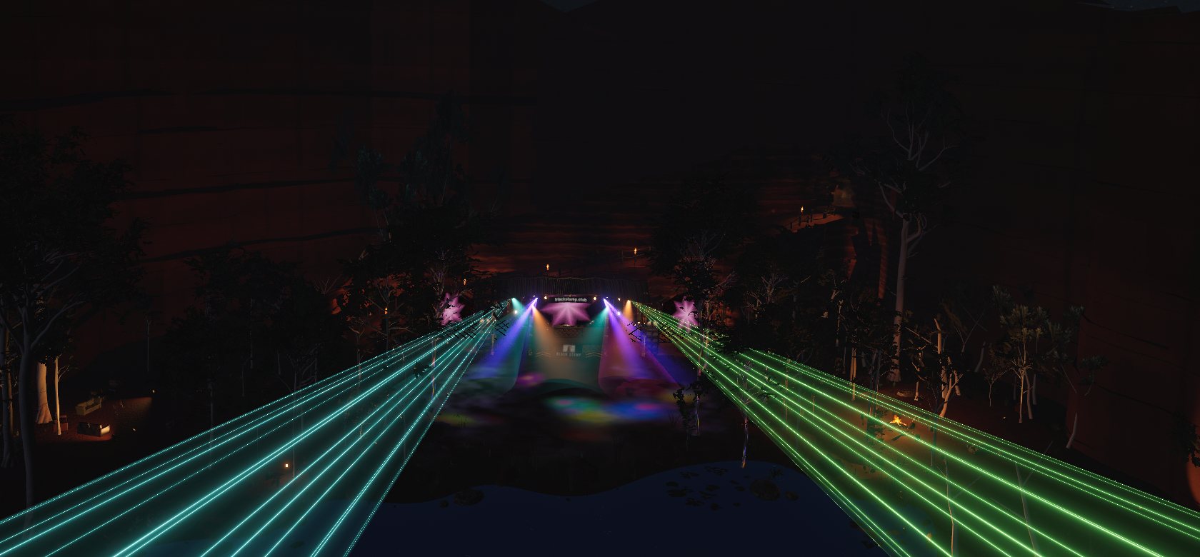 The clearing from above the billabong at night: lasers reaching across the water to the lit stage, the sandstone escarpment rising behind