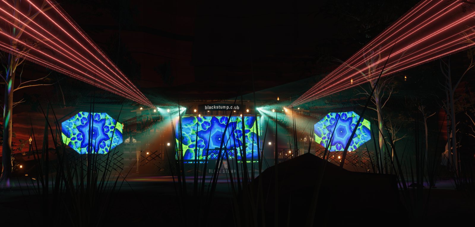The stage from the front, seen through the grass: three kaleidoscope VJ screens, the blackstump.club sign over the booth, red lasers fanning out